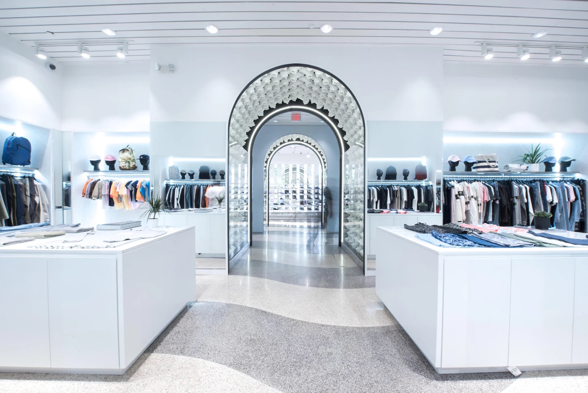 Interior of Kith Miami Beach with symmetrical illuminated arches and clothing displays